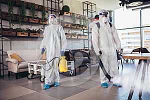 Workers in hazmat suits disinfecting indoor of cafe or restaurant, pandemic health risk, coronavirus photo