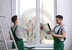 Professional workers tinting window with foil