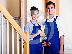 Professional workers with tools at doorway