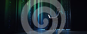 The professional working on a laptop in a modern data center setting. AI generated image