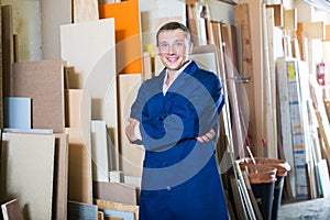 Professional workman standing with plywood pieces