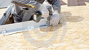 Professional workman using drill, fix the window frame