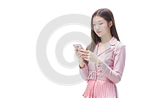 Professional young Asian business woman with long hair smiling in front of the office while using smartphone in her hand to work
