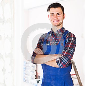 professional young builder standing in repairable room