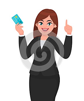 Professional young business woman showing/holding credit/debit/ATM banking card and pointing hand finger up. Modern lifestyle.