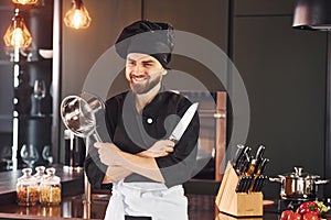 Professional young chef cook in uniform standing and preparing for the work on kitchen