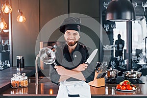 Professional young chef cook in uniform standing and preparing for the work on kitchen