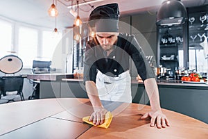 Professional young chef cook in uniform standing and preparing for the work on kitchen