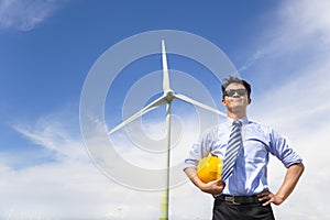 Professional young engineer standing with wind generator