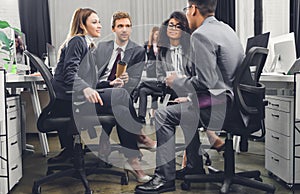 Professional young multiracial business team in formal wear sitting together and discussing work