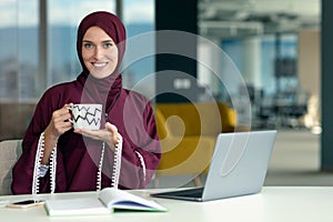 Professional young muslim business woman using mobile digital tablet computer at work