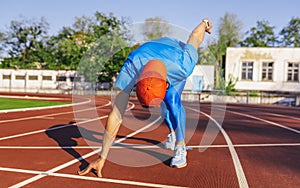 Professional young sprinter athlete male at starting position ready to start a race. Man sprinter ready for sports exercise on