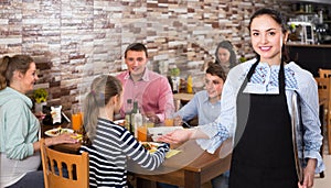 professional young waitress warmly welcoming guests to family cafe