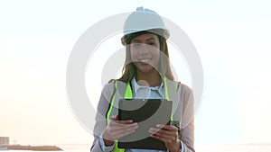 Professional young woman construction worker on site..Expert building instructor reading architectural plan before