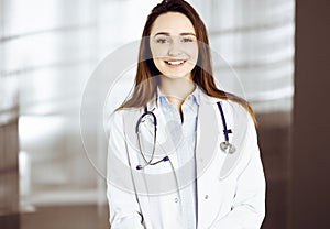 Professional young woman-doctor is looking at camera with a smile. Therapist at work in a clinic's office. Medicine