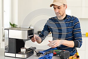 professional young worker fixing coffee machine