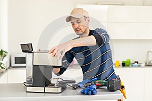 professional young worker fixing coffee machine