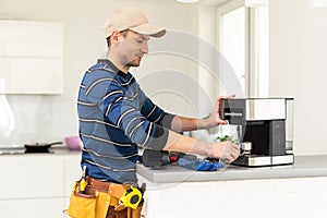 professional young worker fixing coffee machine