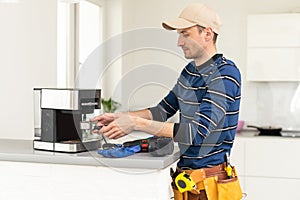 professional young worker fixing coffee machine