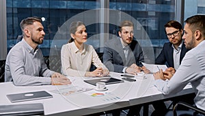 Professionals interviewing a job candidate sitting at desk