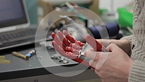 Professionals work with hand bionic prosthesis, at laboratory table indoors.