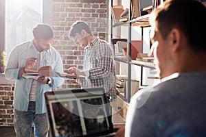 Professionals working on new business project with laptop and books in small business office