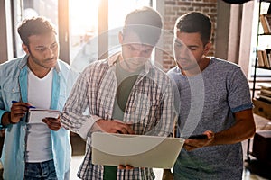 Professionals working on new business project with laptop in small business office