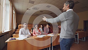 Professor is asking question and pointing at students waiting for answer, young people are raising hands and speaking