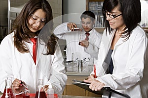 Professor Assisting High School Students In Science Lab
