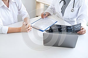 Professor Doctor having conversation with patient and holding x-ray film while discussing explaining symptoms or counsel diagnosis