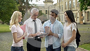 Professor giving assignments to group of multi-ethnic students, education