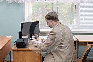 A professor at the institute at his desk by the window