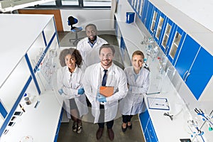 Professor With Mix Race Group Of Scientists In Modern Laboratory Top Angle View Of Smiling Team Of Doctors In Lab