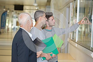 professor with notebook talking to student in corridor
