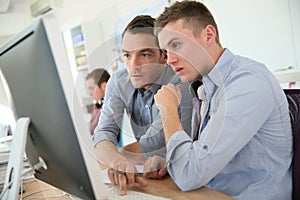 Professor and student working on computer