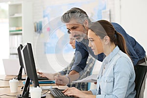 Professor with students working on computer