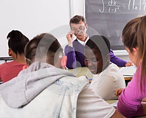 Professor watching as student write off on exams