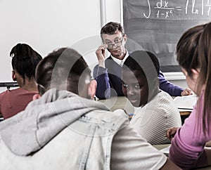 Professor watching as student write off on exams