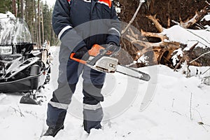 Proffesional Lumberjack hold hand saw. Winter wearing protection clothes using chainsaw. clean fallen trees photo