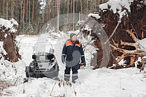 Proffesional Lumberjack hold hand saw. Winter wearing protection clothes using chainsaw. clean fallen trees