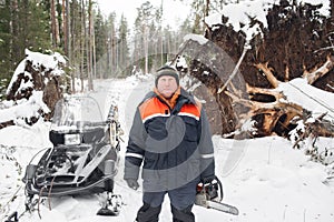 Proffesional Lumberjack hold hand saw. Winter wearing protection clothes using chainsaw. clean fallen trees