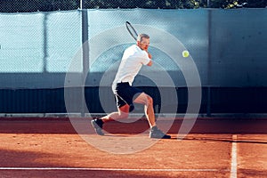 Proffesional tennis player beats off a ball during match