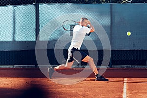 Proffesional tennis player beats off a ball during match