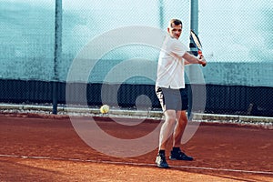 Proffesional tennis player beats off a ball during match