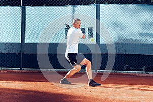 Proffesional tennis player beats off a ball during match