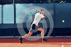 Proffesional tennis player beats off a ball during match
