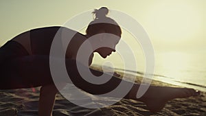 Proffesional yoga woman leaning on hands firefly position at sunset close up.