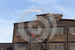 Profile of an abandoned industrial building, circular window in brick facade