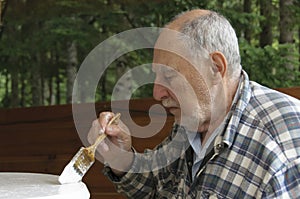 Profile of aged senior man painting