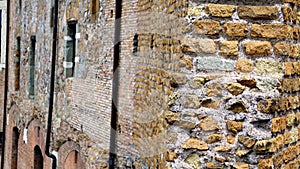 Profile of ancient Roman brick and mortar wall seen in detail with buildings in the blurred background